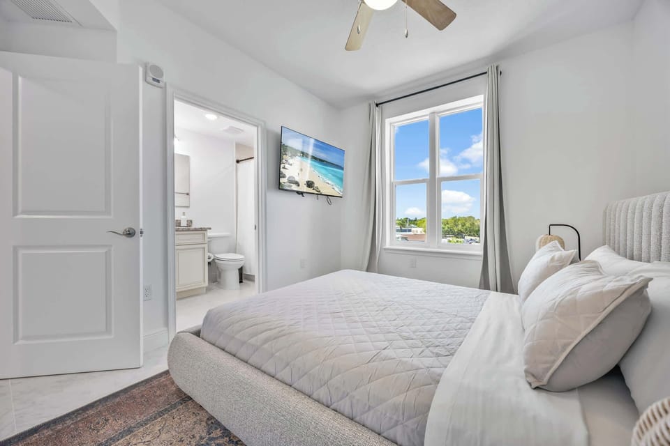 Bright bedroom with a large window and an en suite bathroom for added convenience.