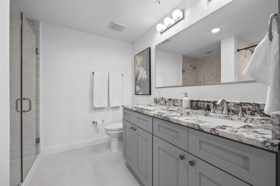 Modern bathroom with dual sinks and a glass-enclosed shower