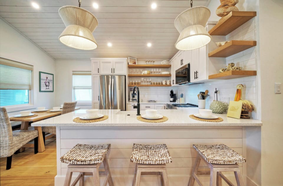 Bright, beautifully finished kitchen with island seating and a welcoming space for slow mornings and shared meals. (Boujee Pelican)