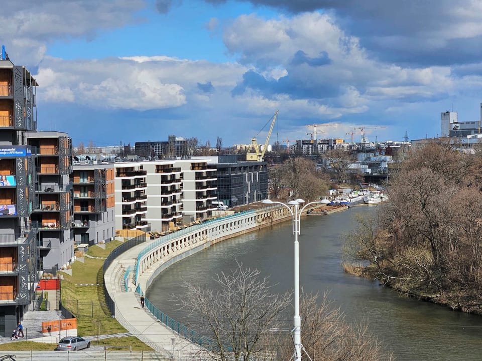 A view from the window of a gently flowing river in Wrocław, creating a pleasant atmosphere and offering a moment of relaxation at any time of day.