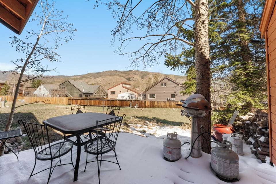 Back patio with outdoor seating, grill, and large shared backyard.