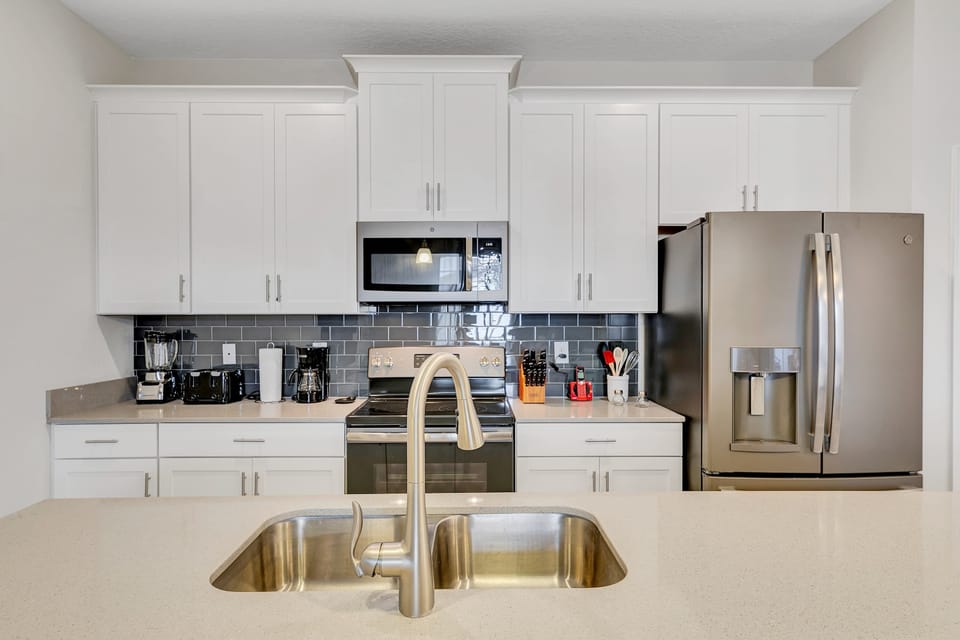 From the coffee maker to the high-end stove, find everything you need for a home-cooked feast in this organized, stylish space.