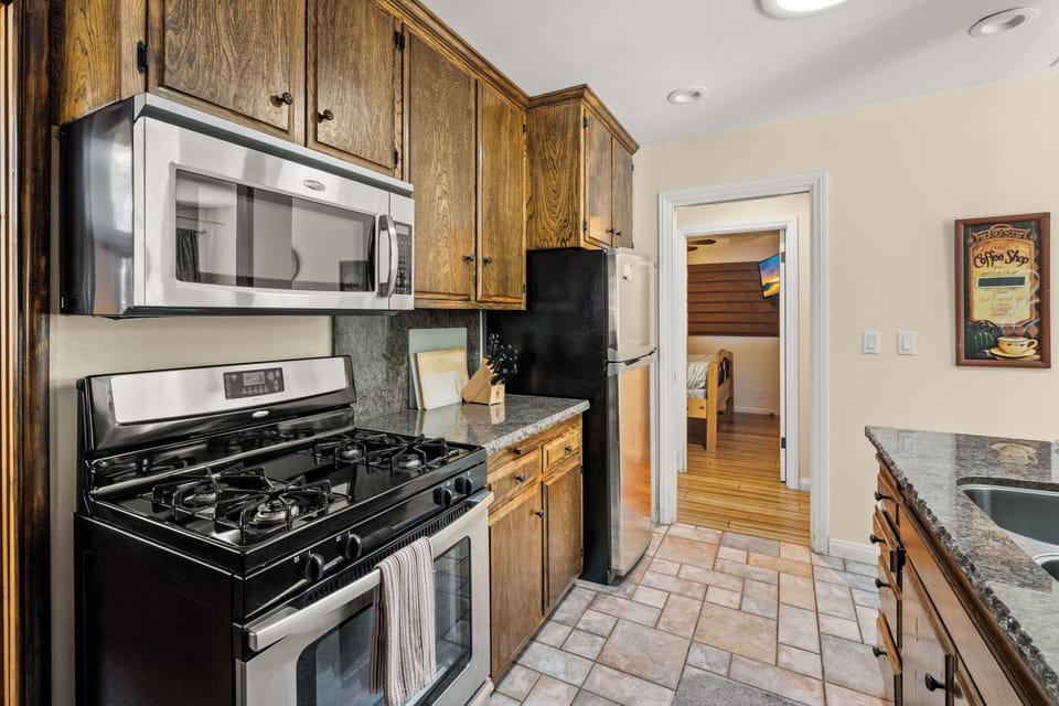 Full Kitchen - The open layout includes a full kitchen, dining area, and a bar space perfect for gathering with everything you need to cook amazing meals.