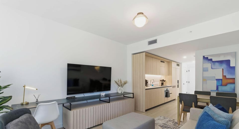 Modern open-concept living room with smart TV and city backdrop
