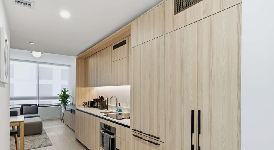 Sleek kitchen with premium appliances and warm wood cabinetry

