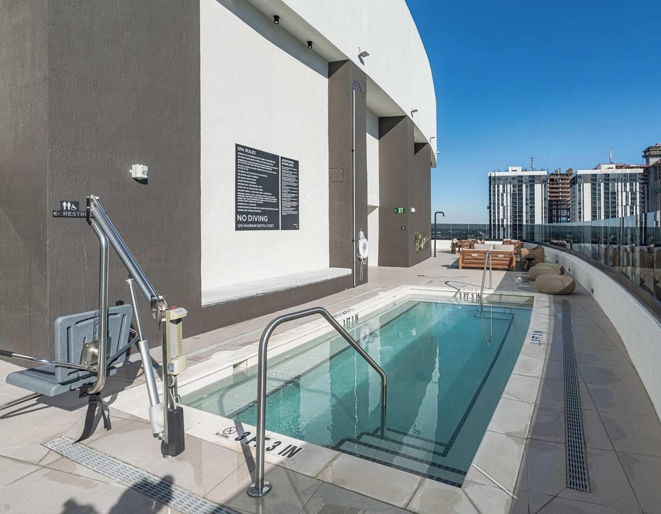 Sparkling rooftop pool with lounge chairs overlooking downtown Miami
