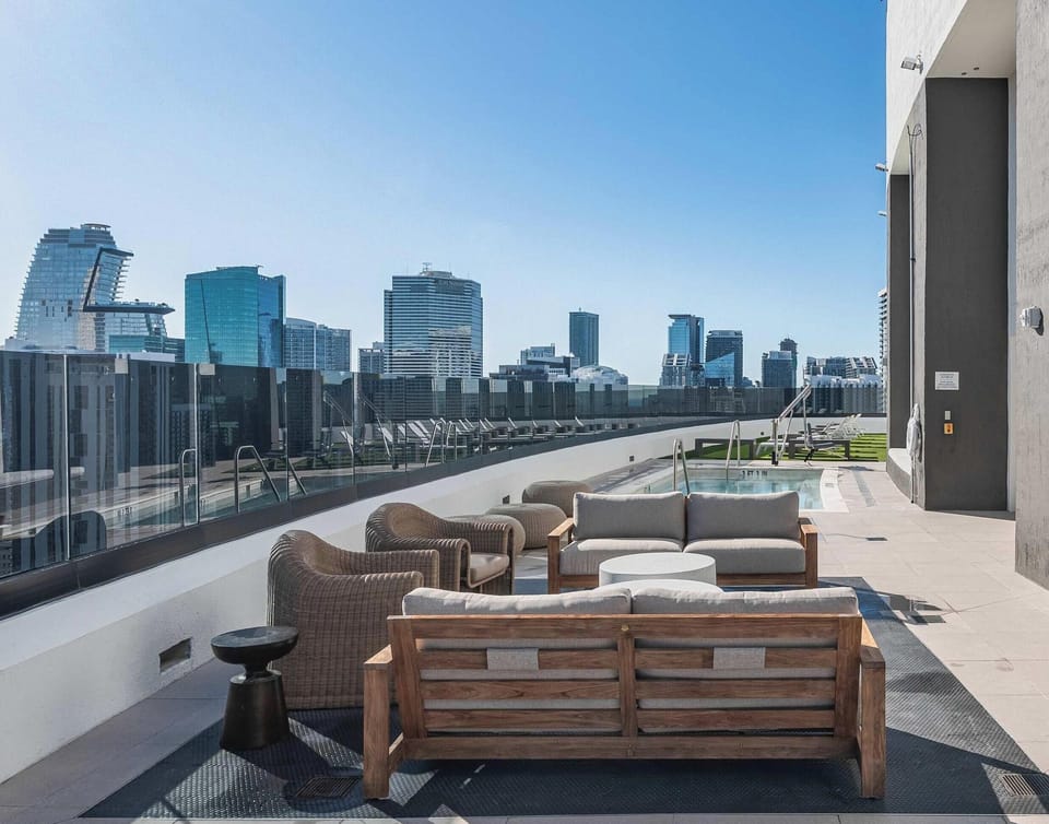 Rooftop terrace with lounge furniture and sweeping city skyline views
