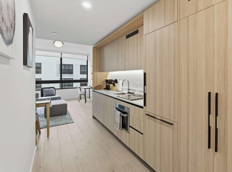 Sleek modern kitchen with wood cabinetry and stainless steel appliances
