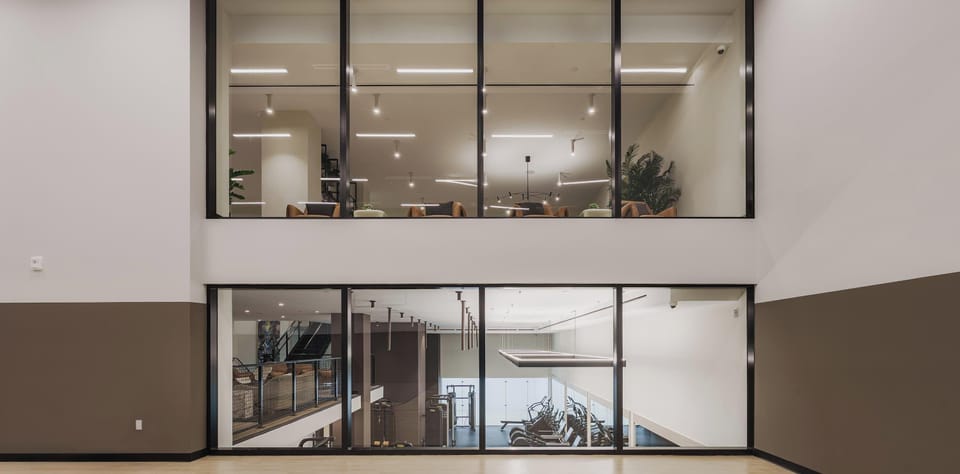State-of-the-art fitness center with modern equipment, visible through floor-to-ceiling glass walls