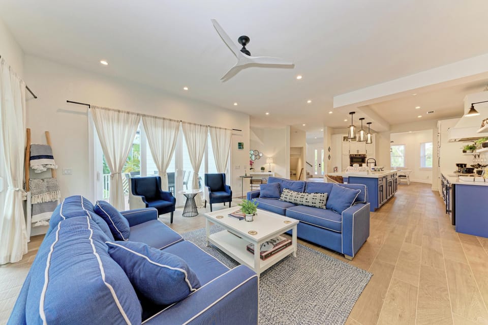 Unwind in this elegant open-plan living space where plush navy seating meets modern comfort, perfect for gathering with loved ones.