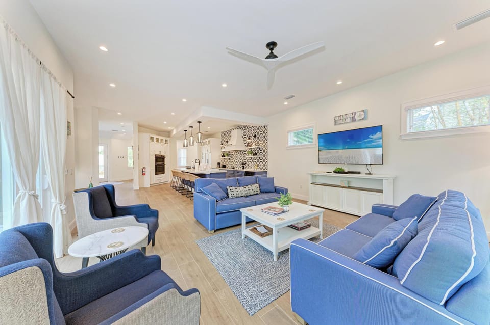 Sink into plush blue sofas in your spacious living room, where ceiling fans keep you cool and the open kitchen invites culinary adventures.