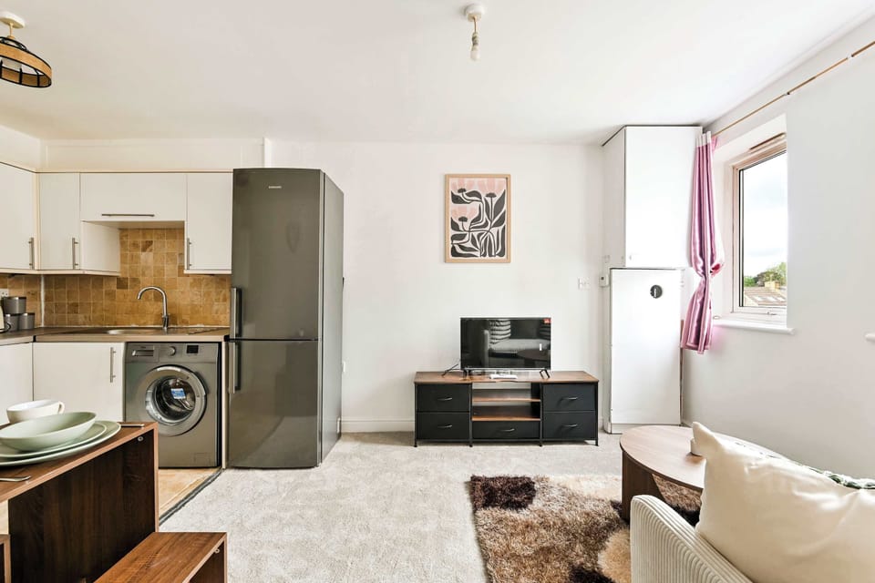 Living Room: Bright and airy space with modern decor, a cozy TV nook, and a functional kitchen!