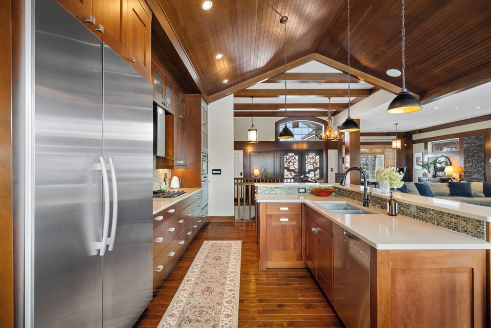 Full size stainless appliances, mosaic backsplash & a vaulted wood ceiling. The chef's kitchen includes a built-in convection microwave & a full convection oven below.