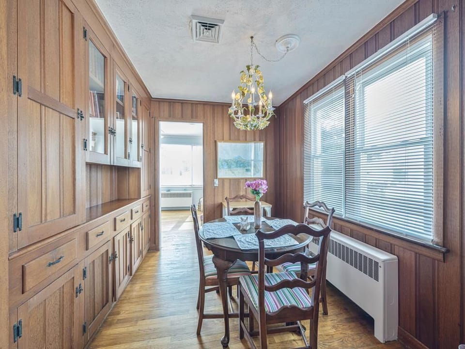 Enjoy meals in this cozy dining space, featuring beautiful natural light and a lovely chandelier.