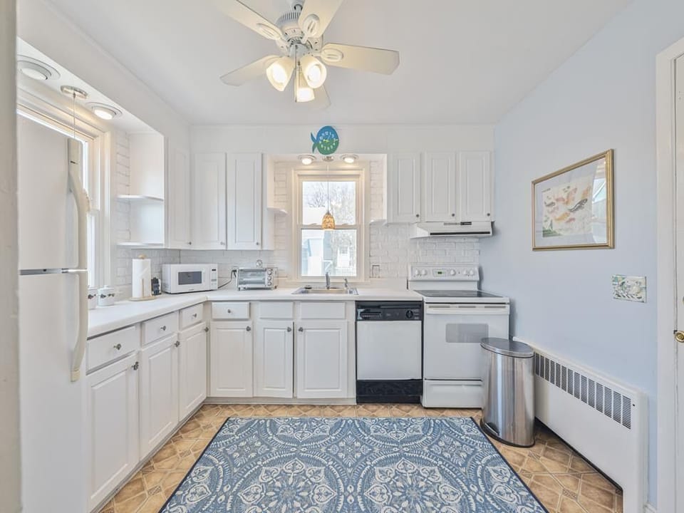 Prepare culinary delights in the airy kitchen, showcasing modern appliances and a soothing color palette.
