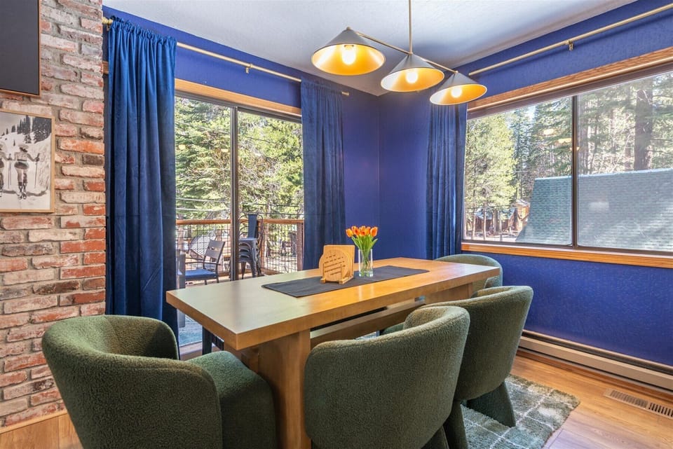 Gather around your elegant dining table where bold blue walls and warm pendant lighting create the perfect atmosphere for memorable meals.