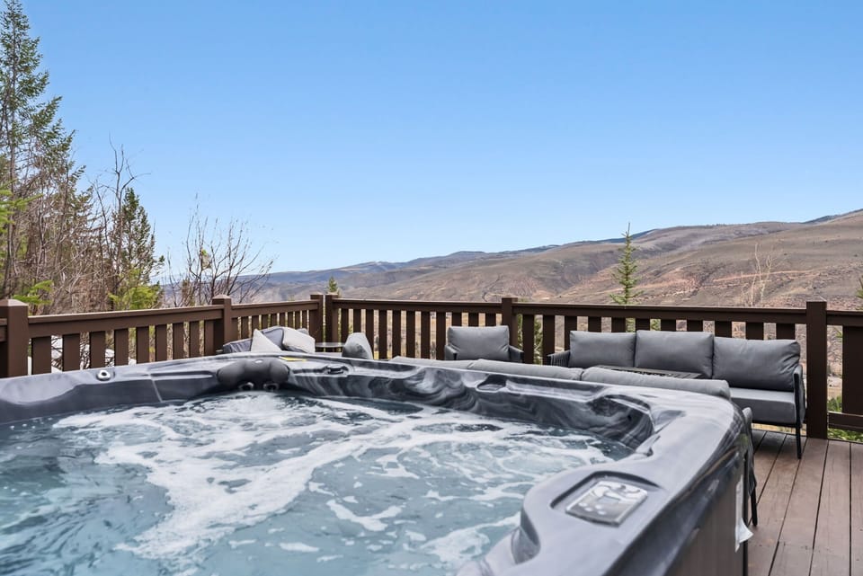 Deck [Exterior]: Outdoor dining area, gas grill, and private hot tub for 6 people with mountain views.