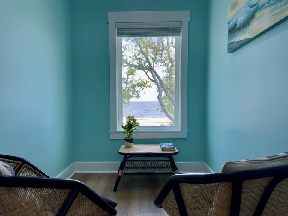 This cozy corner of the bedroom offers a peaceful, light-filled retreat.