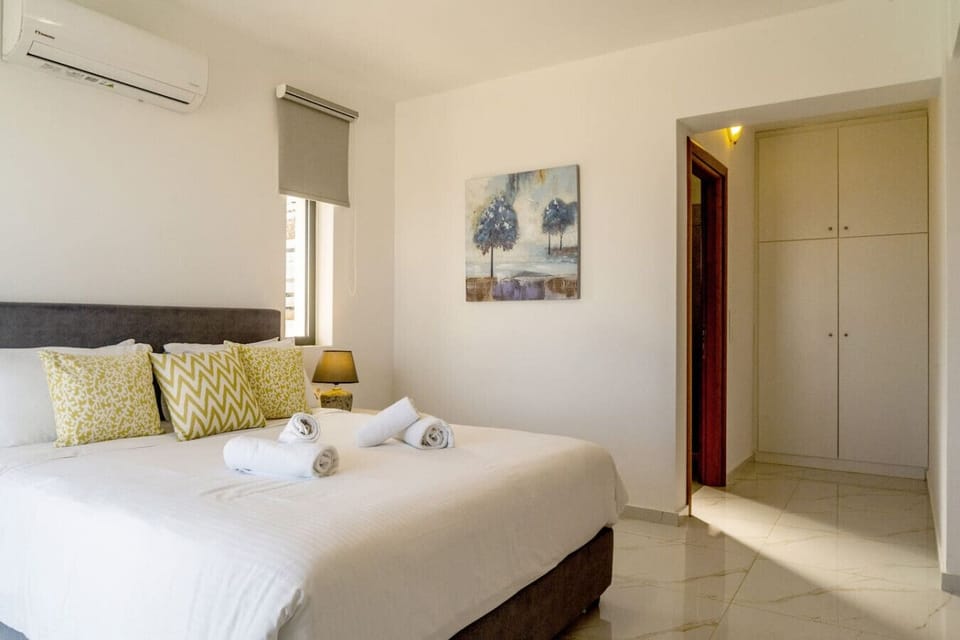 Comfortable bedroom with air conditioning and ensuite bathroom.