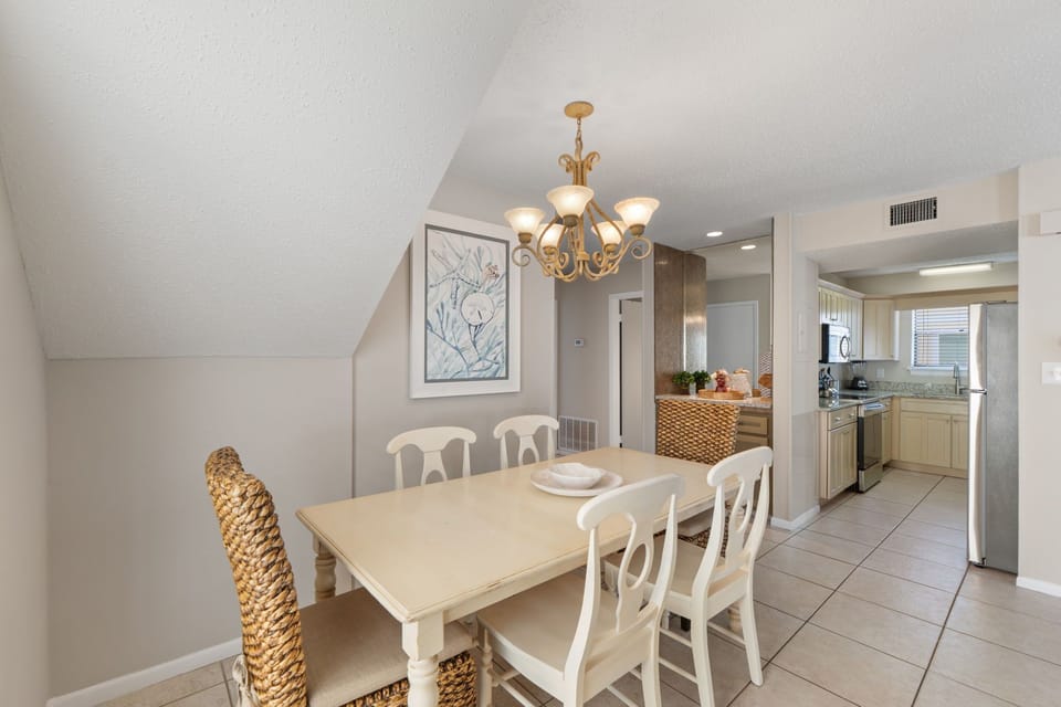 Gather around your elegant dining table under warm chandelier light, with a fully-equipped kitchen just steps away ready for your vacation feasts.