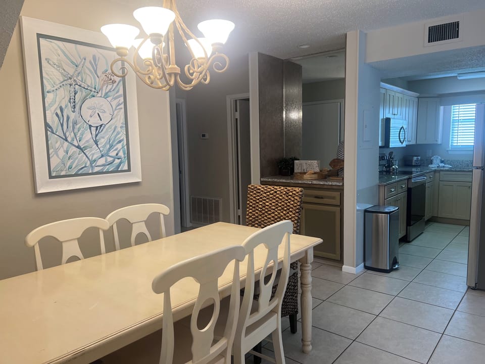 Gather around your elegant dining table under warm chandelier light, with your fully-equipped kitchen just steps away for convenient meal prep.