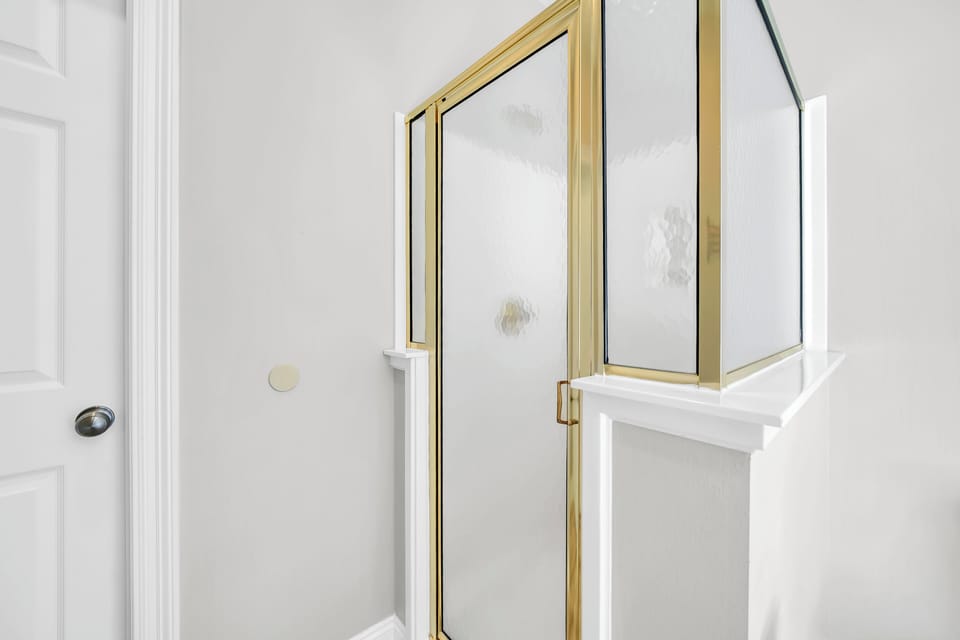 Step into your elegant bathroom featuring stunning gold-framed glass shower doors that add sophisticated luxury to your daily routine.