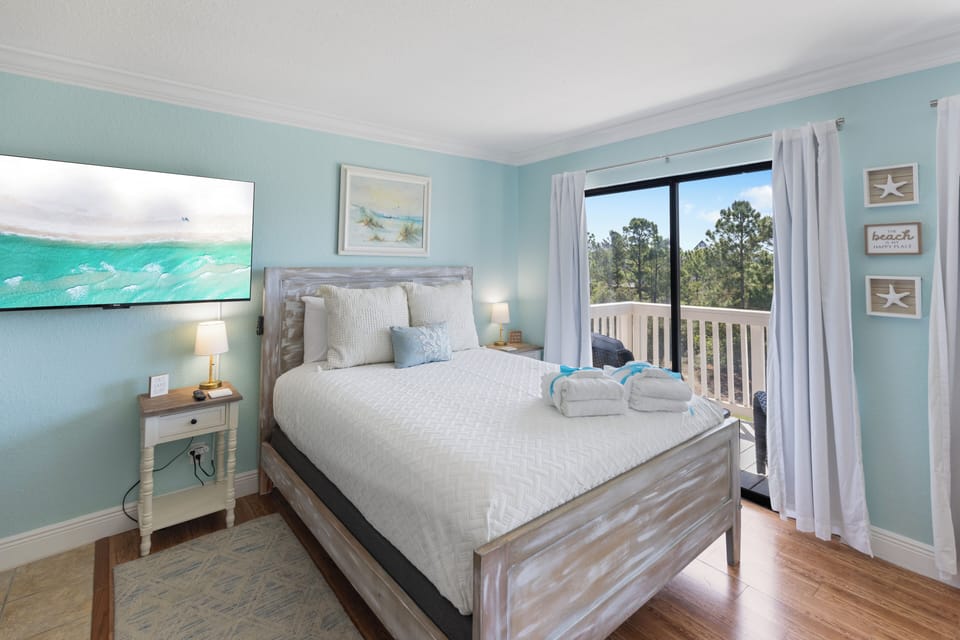 Drift off to sleep in this coastal-themed bedroom where soft ocean hues and warm wood floors create your perfect seaside sanctuary.
