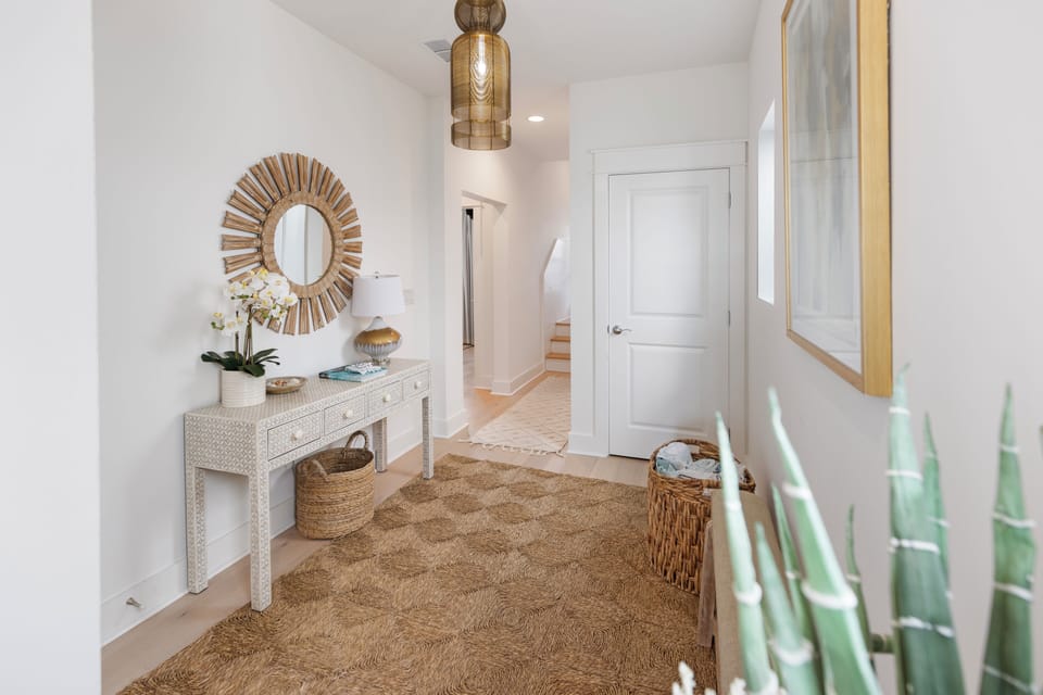 Step into your serene entryway where coastal elegance meets comfort—polished floors, warm textures, and thoughtful decor create an inviting welcome home.