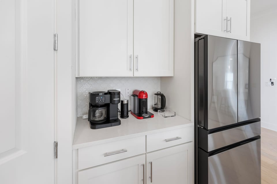 Start each morning with fresh coffee from your dedicated beverage station, complete with premium appliances and sleek stainless steel refrigerator.