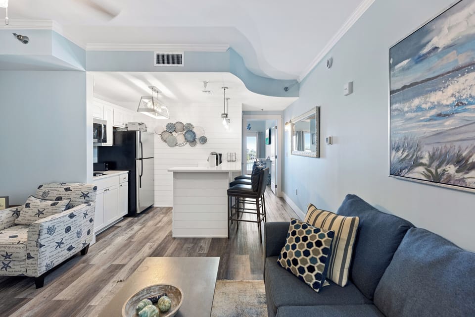 Sink into coastal comfort in your bright, open-concept space where soothing blues and beach artwork create your perfect seaside retreat.