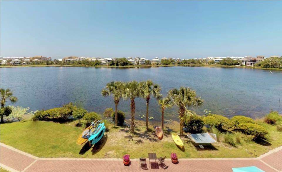 Serene lakefront setting with palm trees and kayaks ready for exploration in this peaceful residential community.