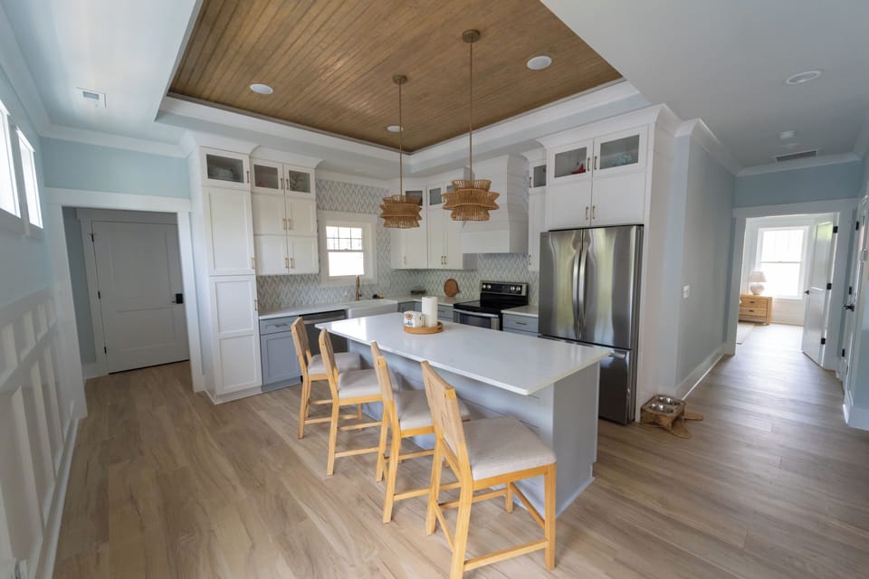 Bright coastal kitchen with island seating and warm designer touches