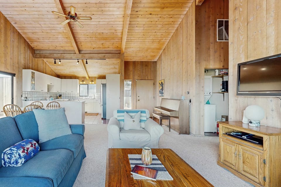 The open floor plan brings the kitchen, dining area, and living room together under soaring vaulted ceilings -- notice the piano in the corner for impromptu concerts.