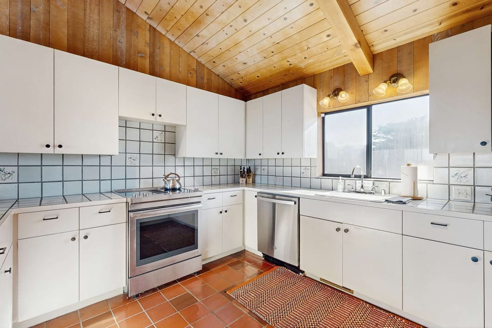Stainless steel appliances, generous counter space, and warm terra cotta tile floors make this kitchen a pleasure to cook in.