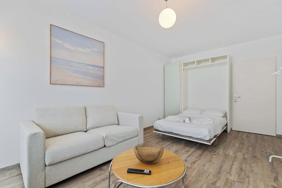 Comfortable seating area next to the bed, offering a relaxing space to unwind in a bright and modern setting