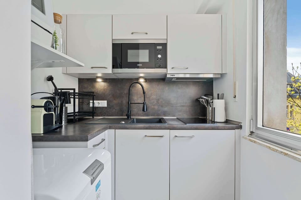 Fully equipped modern kitchen with all essentials including stove, microwave, coffee maker, and dishwasher for convenient stays