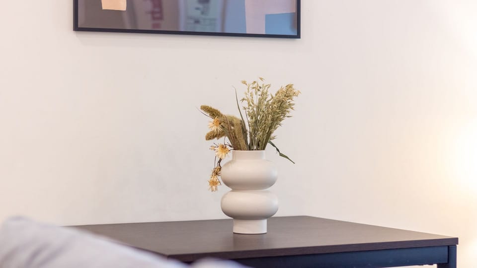 Subtle artistic touches, like this elegant vase with dried flowers, add a homely and sophisticated ambiance to your stay, creating a serene and inviting atmosphere. These thoughtful details contribute to a truly relaxing and memorable experience.