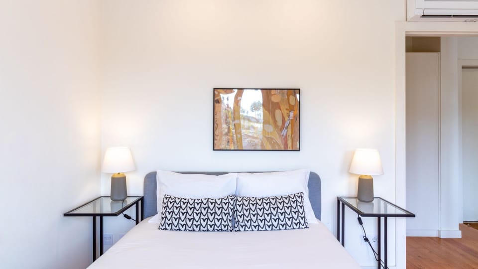 Retreat to this cozy bedroom, where soft bedside lighting and a comfortable bed await to ensure a peaceful night's sleep after a day of exploring. The tasteful wall art adds a touch of sophistication, creating a serene and inviting atmosphere.