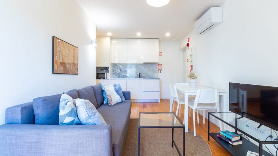 Enjoy open-plan living where preparing a meal in the sleek, fully equipped kitchen flows effortlessly into dining and relaxing on the comfortable sofa, creating a perfect hub for your stay. #OpenPlanLiving #SleekKitchen #ComfortableSofa #ModernApartment #