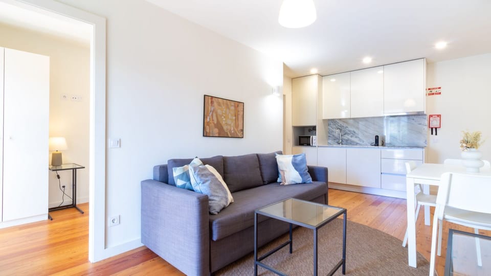 Unwind in this comfortable living space, featuring a plush sofa and direct access to the modern, well-equipped kitchenette, perfect for preparing light meals. It's an ideal spot to relax after a day of exploring, offering both style and practicality for y