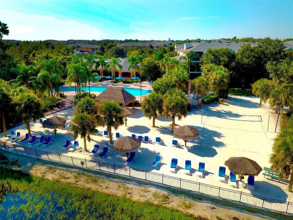 Resort-style pool area with lounge chairs, palm trees, and a relaxing atmosphere.