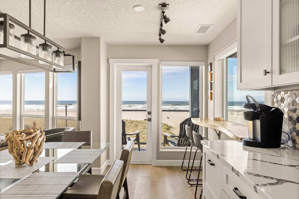 Modern kitchen and dining area with ocean views, breakfast bar, and stylish finishes—perfect for cooking and entertaining.