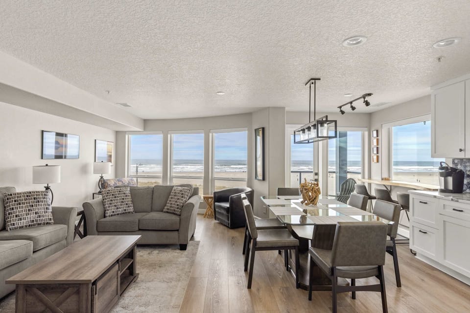 Stunning open-concept living and dining area with panoramic ocean views, modern furnishings, and bright coastal design—perfect for relaxing stays.
