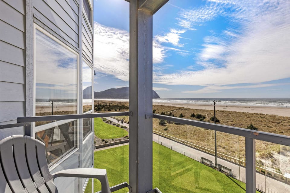 Relax on your balcony with panoramic views of the coastline, beach dunes, and scenic mountain horizon.