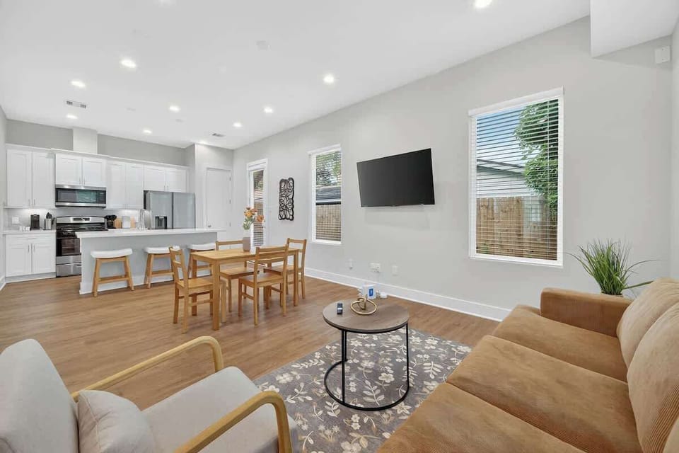 Modern open-plan living with a full kitchen, stainless appliances, and Smart TV.