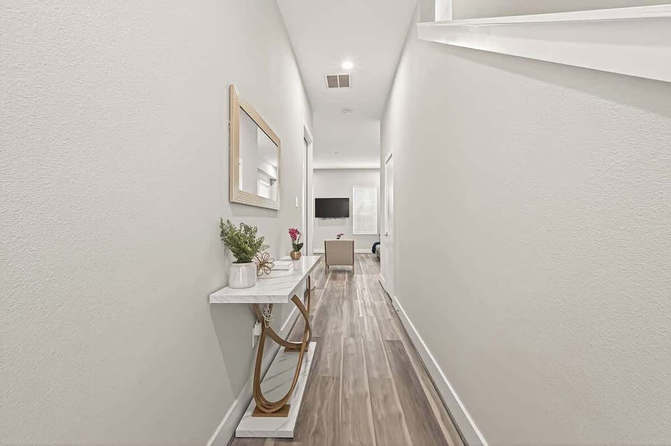 Bright, modern hallway with stylish console table, elegant décor, and seamless flow to the living space—welcoming and guest-ready.