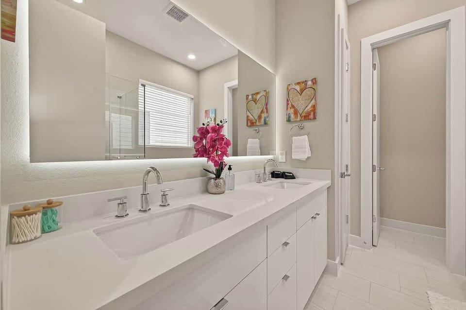 Spa-Like Bathroom Retreat: Experience elegance with dual sinks, vibrant decor, and bright natural light