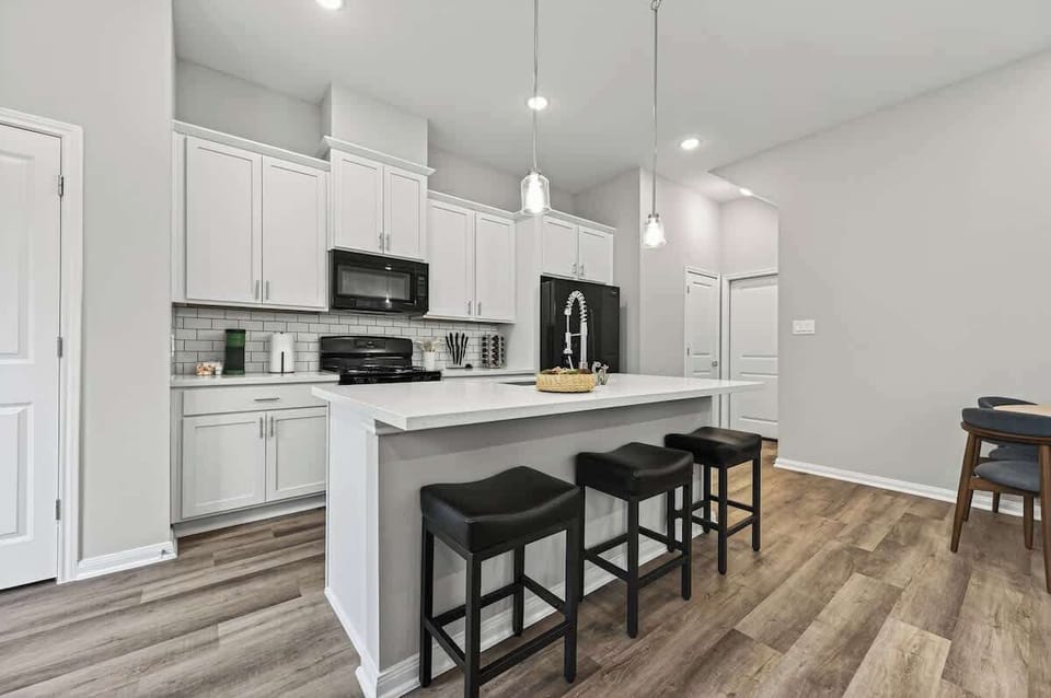 Modern, fully equipped kitchen with sleek appliances, spacious countertops, and a large island with seating. Perfect for cooking, gathering, and enjoying meals together. Bright, clean, and designed for convenience during your stay.