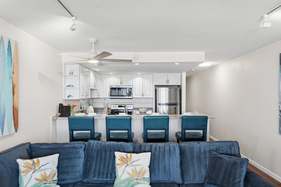 Living room overlooking the remodeled kitchen and breakfast bar seating.