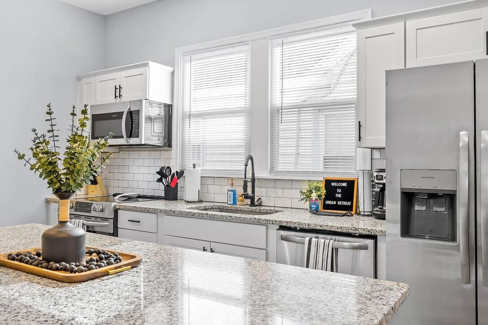 A fully equipped, modern kitchen with deep basin sink, stainless appliances, drip coffee, and a spacious island—perfect for cooking, gathering, and easy access to Bedroom 2 and the bathroom.
